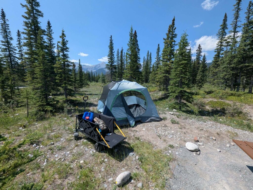 BougeRV electric folding utility wagon parked beside a tent at a gravel campsite in Alberta